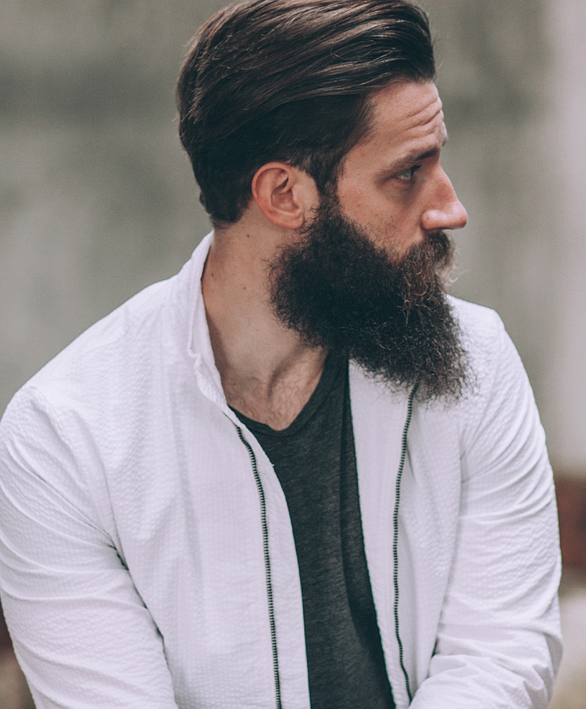 Man with beard, styled hair, wearing jacket.